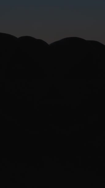 バーティカルビデオ ハロウィーンのカボチャが暗闇の砂の上に立って 突然照らされた — ストック動画