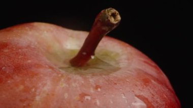 Bir damla su, kırmızı bir elmanın teneffüsüne düşer. Döndürme, Yavaş Hareket, makro