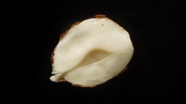 Fındığın yarısını böl, siyah bir arkaplanda dön, yakın plan..