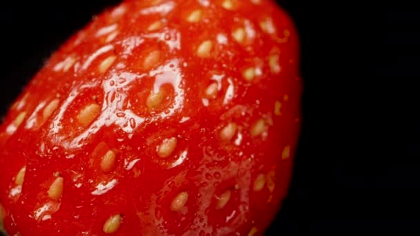 草莓是横向旋转的 极端宏观 慢慢下降和移动 孤立的黑色背景 — 图库视频影像