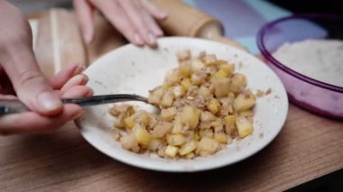 Genç bayan ayva ve ceviz dolgusunu al ve turta için hamurun üzerine koy..