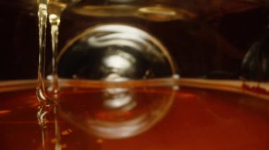 Kamera bal kavanozunun içinde, içeri akıyor ve yukarıdan damlıyor. Dolly kaydırıcı aşırı yakın çekim.