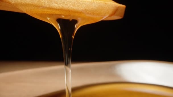 Honig Aus Einem Holzlöffel Fließt Einen Teller Schieberegler Extreme Nahaufnahme — Stockvideo