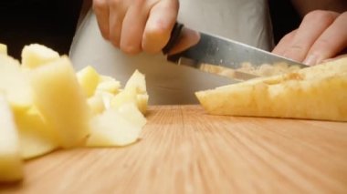 Genç kadın, masanın bile sallandığı baldır küplerini keserken kamera gittikçe yaklaşıyor. Makro.