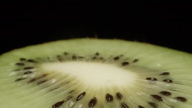 Kivi yarısı yavaşça döner, kamera geri çekilir. Yakın plan..