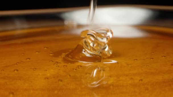 Ένα Λεπτό Ρυάκι Μέλι Χύνεται Ένα Διάφανο Πιάτο Μέλι Κοντινό — Αρχείο Βίντεο
