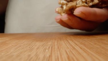 Ahşap bir masaya bir avuç soyulmuş ceviz atıyorum, yakın plan..