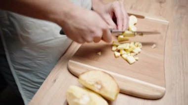 Genç kadın ahşap bir tahtanın üzerinde bıldırcın küpleri kesiyor, kamera daire şeklinde hareket ediyor, yakın plan..