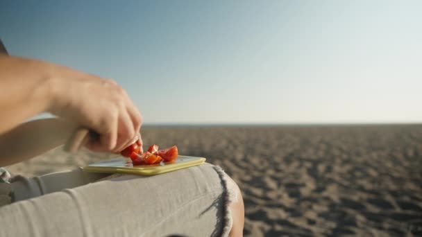 一位在海边的年轻女子正在准备蔬菜沙拉 切西红柿 放进沙拉碗里 — 图库视频影像
