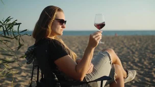 Jonge Vrouw Zit Een Klapstoel Aan Zee Roert Wijn Een — Stockvideo