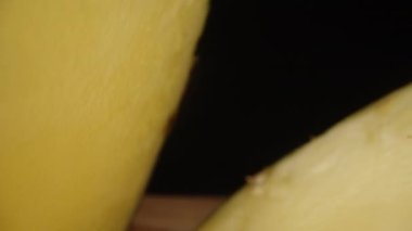Tahta bir masanın üzerinde yaprakları yuvarlak dilimlere kesilmiş koca bir ananas. Dolly sürgülü çok yakın çekim..