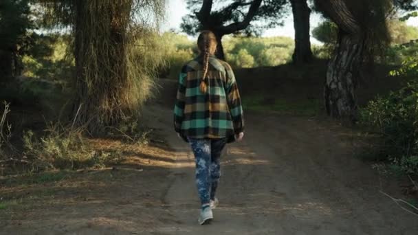 Uma Jovem Mulher Uma Camisa Xadrez Leggings Azuis Caminha Pela — Vídeo de Stock