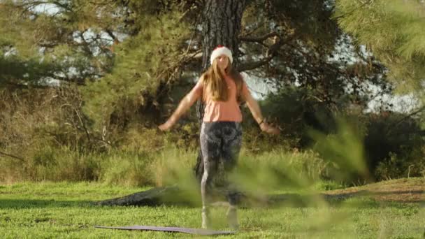 Молода Жінка Санта Капелюсі Займається Спортом Лісі Стрибає Розмахує Руками — стокове відео