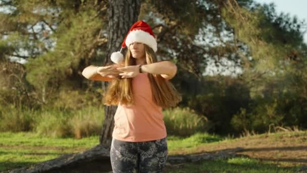 Een Jonge Vrouw Met Een Kerstmuts Doet Een Warming Het — Stockvideo