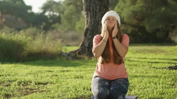 Een Jonge Vrouw Met Een Kerstmuts Een Yogamat Het Bos — Stockvideo