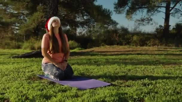 Jonge Vrouw Met Een Rode Nieuwjaarshoed Mediterend Een Kleed Het — Stockvideo