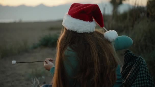 Молода Жінка Новорічній Червоній Шапці Смажить Зефір Пляжі Біля Моря — стокове відео