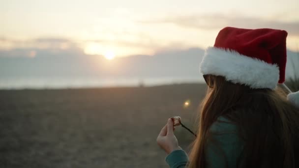 Молода Жінка Капелюсі Санта Тлі Гір Заходу Сонця Їсть Смажені — стокове відео