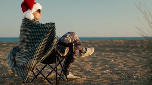 Ung Kvinde Santa Hat Plaid Sidder Stol Ved Havet Fejrer – Stock-video
