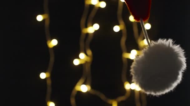 Der Rote Hut Des Weihnachtsmannes Schwingt Und Fällt Auf Schwarzem — Stockvideo