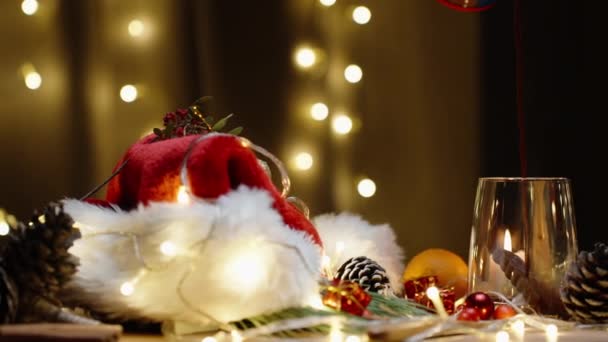 Karácsonyi Asztal Szétszórt Dekorációval Gyertyákkal Koszorúkkal Forró Kakaót Öntök Egy — Stock videók