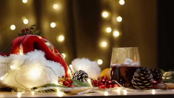 我把棉花糖扔进热可可里 圣诞桌上有装饰品和糖果 蜡烛和一个花环在燃烧 慢动作 — 图库视频影像