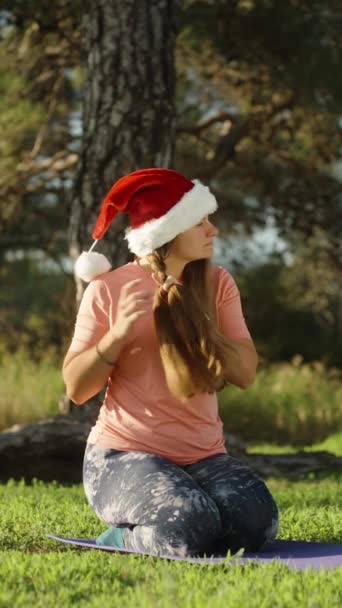 Вертикальне Відео Молода Жінка Червоному Капелюсі Санта Сидить Килимку Йоги — стокове відео