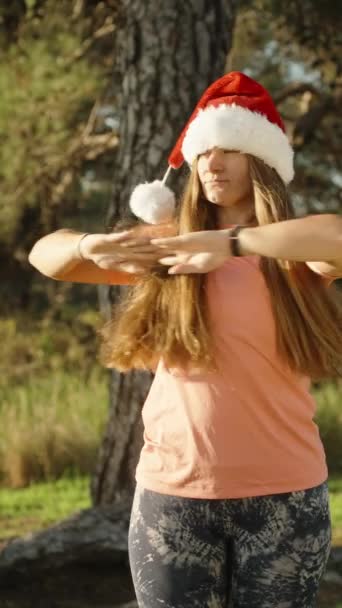 Verticale Video Een Jonge Vrouw Met Een Kerstmuts Warmt Zich — Stockvideo