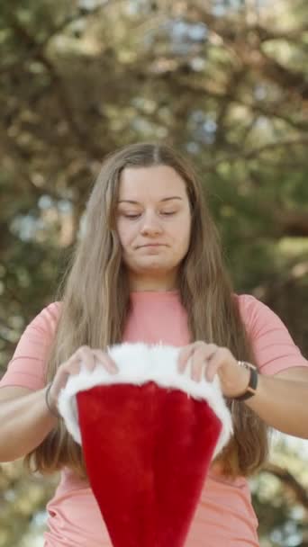 Verticale Video Een Jonge Vrouw Zet Een Rode Kerstmuts Het — Stockvideo