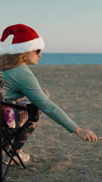 Вертикальне Відео Різдво Біля Моря Молода Жінка Червоному Капелюсі Санта — стокове відео