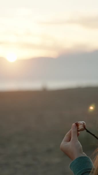 Вертикальне Відео Молода Жінка Капелюсі Санта Їсть Смажений Зефір Пляжі — стокове відео