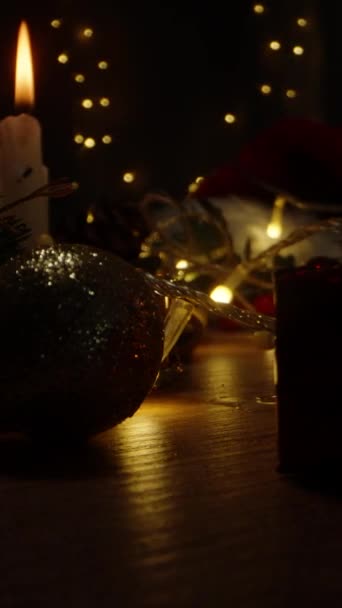 垂直录像 圣诞之夜 桌上的装饰品和礼物 蜡烛和灯笼在黑暗中摇曳 — 图库视频影像