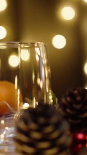 バーティカルビデオ クリスマスデコレーションのテーブル サンタの帽子 ピンセノンからの空のカップ モーションで クローズアップ — ストック動画