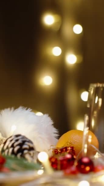 バーティカルビデオ 散らばった装飾 ろうそく ガーランドのクリスマステーブル チョコレートをグラスに入れた スローモーション — ストック動画