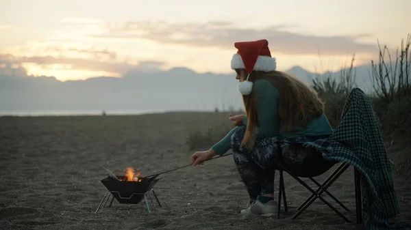 Uma Jovem Com Chapéu Vermelho Pai Natal Está Fritando Marshmallows — Fotografia de Stock