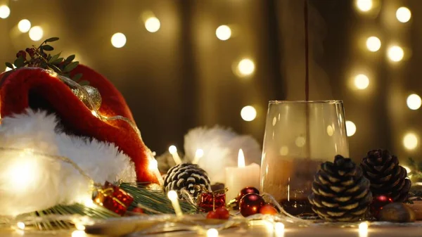 ホットチョコレートを注いで 明かりのガーランドの背景に蒸気を注ぐ ろうそくと装飾が付いているクリスマス テーブル — ストック写真