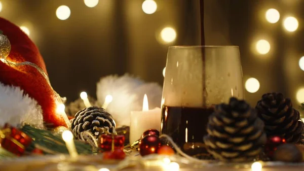 ホットチョコレートをライトのガーランドの背景に注いでいます ろうそくと装飾が付いているクリスマス テーブル — ストック写真