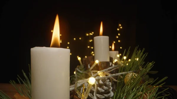 在黑暗中的花环背景下 烛光是在手工制作的新年装置中点燃的 — 图库照片