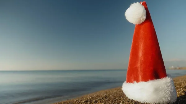 Chapéu Papai Noel Vermelho Colocado Praia Arenosa Pelo Mar Uma — Fotografia de Stock