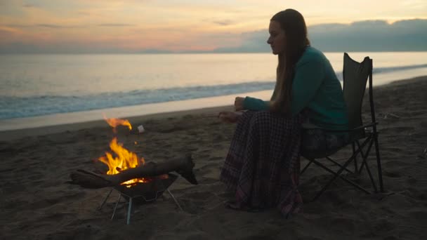 Молода Жінка Заході Сонця Біля Моря Смажить Зефір Багатті Холодно — стокове відео