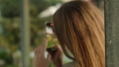 Parkta otururken telefonuyla fotoğraf çeken genç bir kadını gözetliyordum. Beni fark etti ve arkasını döndü. Yakın plan.