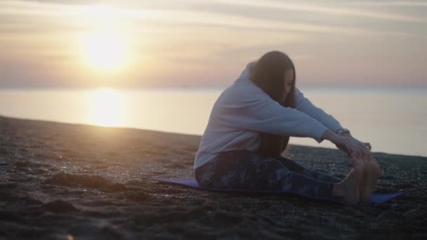 Młoda Kobieta Wschodzie Słońca Rozciąga Się Macie Jogi Plaży Nad — Wideo stockowe