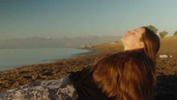 这个年轻的女人一大早就躺在海滨 享受着阳光 绕着圈子射击 — 图库视频影像