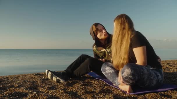 若いカップル男性と少女は海岸で日の出に会い キスをするために周りの愚か者 — ストック動画