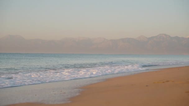 Sandy Sahili Nde Şafak Vakti Güneş Denizin Uzaklığındaki Dağları Aydınlatır — Stok video