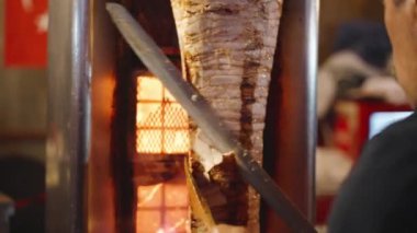Sokak yemekleri, Büyük Bıçaklı Bir Adam Shawarma İçin Etin Bitmiş Parçalarını Kesiyor.