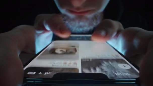 一个留着胡子的男人迅速地在网上浏览照片 黑暗中的特写 — 图库视频影像