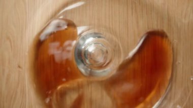 Ben içine kırmızı nar ya da kiraz suyu dökerken kamera bardaktan fırlıyor. Tahta bir masa üzerinde, Macro Kaydırağı