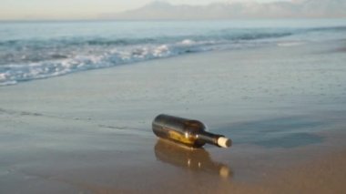 Kumsalda, içinde bir not olan bir şişe Ashore 'a atıldı ve bir mantarla kapatıldı. yakın plan