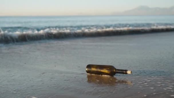 一个装有字母的玻璃瓶 波浪把它抛向岸边 慢吞吞地移动着 — 图库视频影像